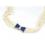 A multi strand seed pearl necklace, having a 14ct gold lapis lazuli and diamond deco bow clasp, 75cm