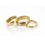 Three gold wedding bands, including a gentleman's 9ct gold D shaped example, ring size Y, 6.5g, an