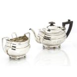 An Edwardian silver teapot and sugar basin by E.W & Co, on four bun supports with gadrooned rims,