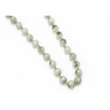 A Chinese pale jadeite Jade uniform string of knotted beads, with silver filigree Chinese clasp,