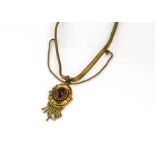 A Victorian gilt metal and cabochon red paste pendant, the fine chain with tongue and barrel clasp