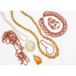 Two 19th Century coral bead necklaces, an amber pendant, a 19th Century bone carved brooch of a