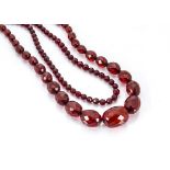 A cherry amber style graduated faceted bead necklace, 84cm, together with another uniform faceted