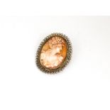 A shell cameo and silver gilt filigree mounted brooch, of oval design with profile of a young