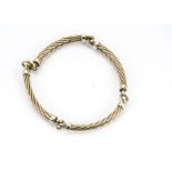 A 9ct gold two colour bracelet, the four curved, plaited links with white gold terminals marked 9ct,