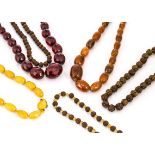 A graduated string of faceted 'cherry amber' beads, two simulated amber necklaces and two carved