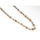 A 19th Century gilt metal necklace, the nine faceted, oval batons alternately set with faceted beads