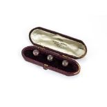 A set of three 18ct gold garnet set dress studs, in fitted Samuel Dixon leather and velvet lined