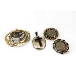 A collection of Victorian mourning jewellery, including two plaited hair in memory brooches, one