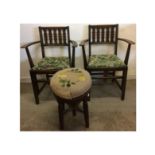 A pair of Ercol arm chairs, stained wood with drop in seats of tapestry upholstery, both with