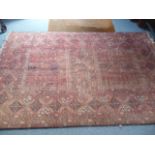 A large red ground Turkmen rug, having central square medallions, with geometric design, 240cm x