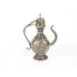 A 19th Century Indian white metal ewer, unmarked, of baluster form profusely embossed with flowers