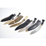 A group of four Middle Eastern Kukri knives, one having bone handle with decorative white metal