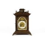 A 19th Century German mantle clock, the dial with Roman numerals surmounted by a brass putti, in a