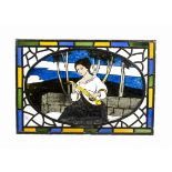 An early 20th Century stained glass panel, with central oval image of a seated young lady playing