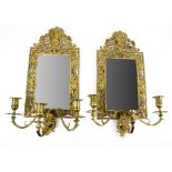 A good pair of brass girandole mirrors, the bevelled glass surrounded by intricate metal work with