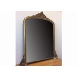A large 19th Century gilt arch top over mantle mirror, with scrolling corbelles and ceramic feet,