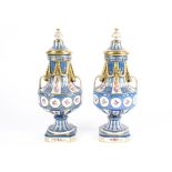 A Sevres style pair of French porcelain lidded vases, each rising from a square plinth, reserved
