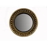 A George IV circular giltwood mirror, c.1830, the convex plate in reeded ebonised slip and cavetto