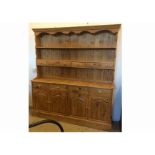 A contemporary pine dresser, the base comprising four arch panelled doors below four short