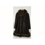 A Vintage brown leather coat, swing' style, with a fox fur collar and hem and a brown faux fur