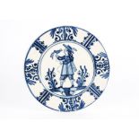 An 18th Century Delft charger, glazed in blue and white, bearing a central image of a gentleman