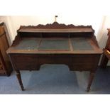 A 19th Century mahogany kneehole writing desk, with shaped gallery back, with a rising writing slope
