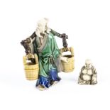 A Chinese glazed pottery watercarrier figure, height 12.5cm, together with a bone figure of a rotund