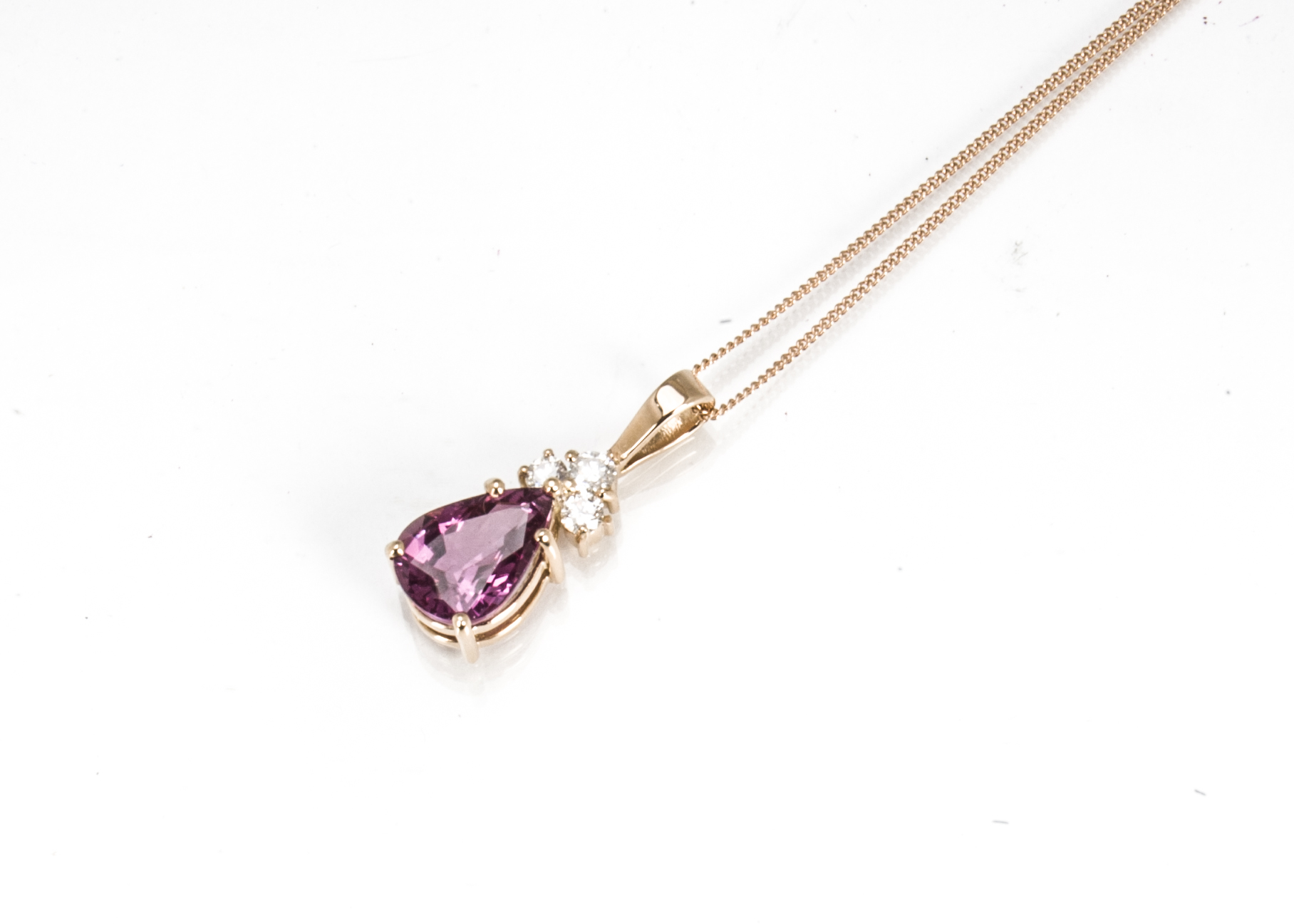 A certificated pink sapphire and diamond pendant, the pear shaped faceted mixed cut sapphire in claw