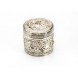 An early 20th century Indian silver cannister, the circular box and cover with embossed ornate