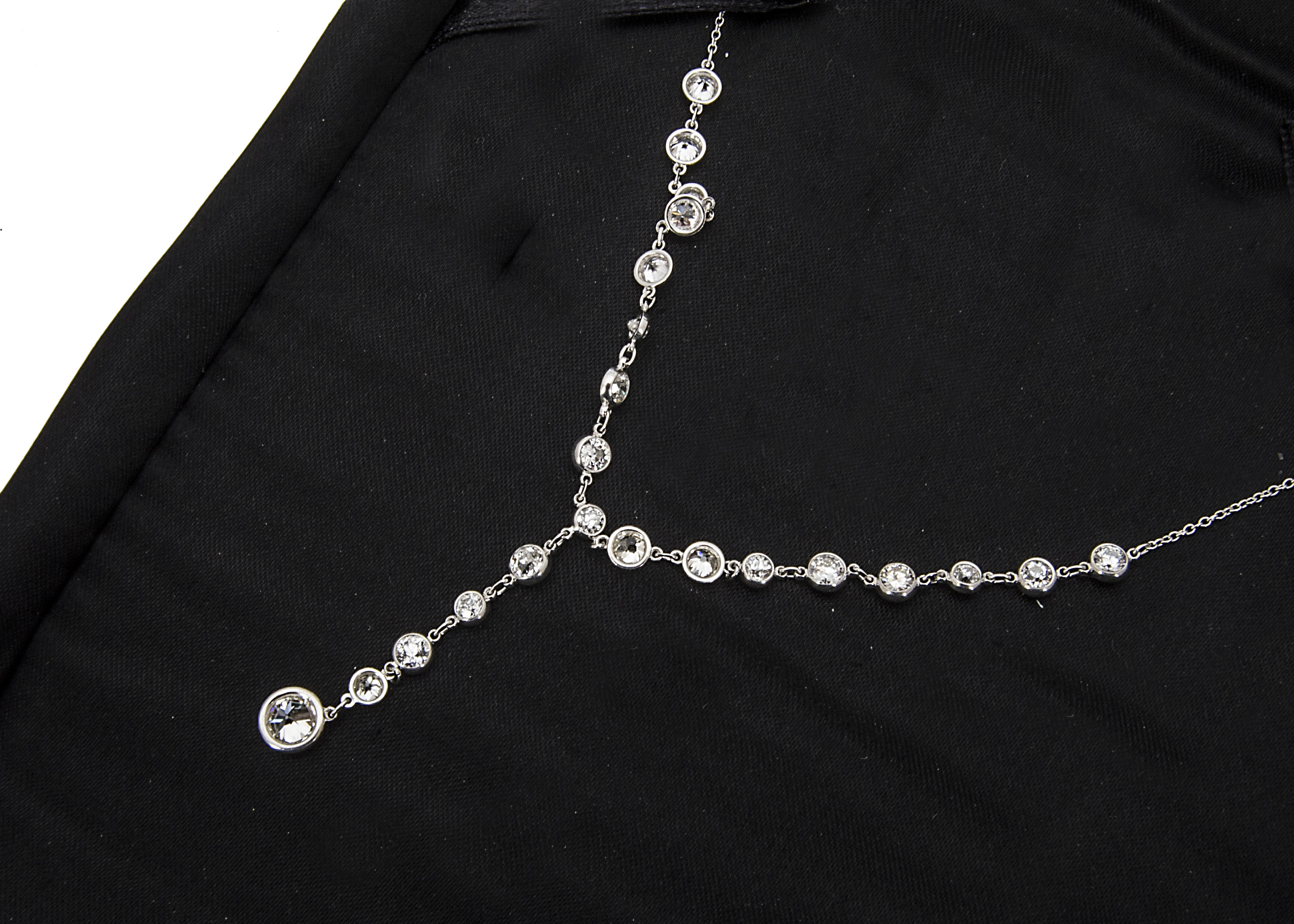 A platinum and diamond fringe and drop necklace, the fine chain supporting twenty two brilliant