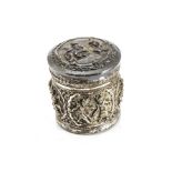 A late 19th century Burmese silver cannister, the circular box and cover with embossed ornate raised