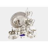 A collection of silver plated tableware items, including a glass jug on warmer stand, an oval