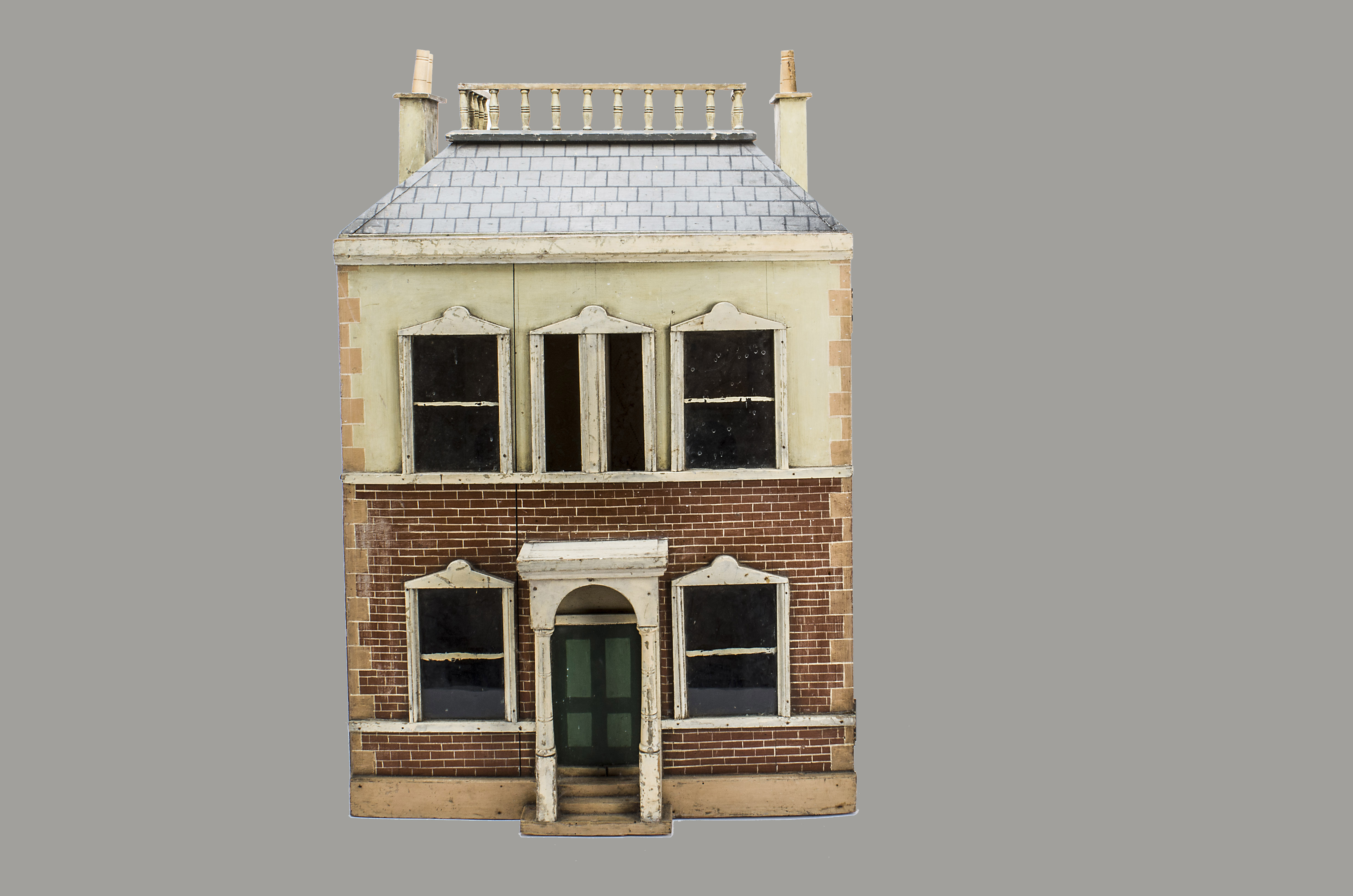 A painted wooden dolls’ house, the painted stone and brick facade with central dummy front door with