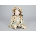 An Armand Marseille 323 googly eyed doll, with brown glass eyes, closed smiling mouth, brown