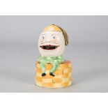 An unusual Humpty Dumpty porcelain stamp licker, seated on a wall with well for water, when you lift