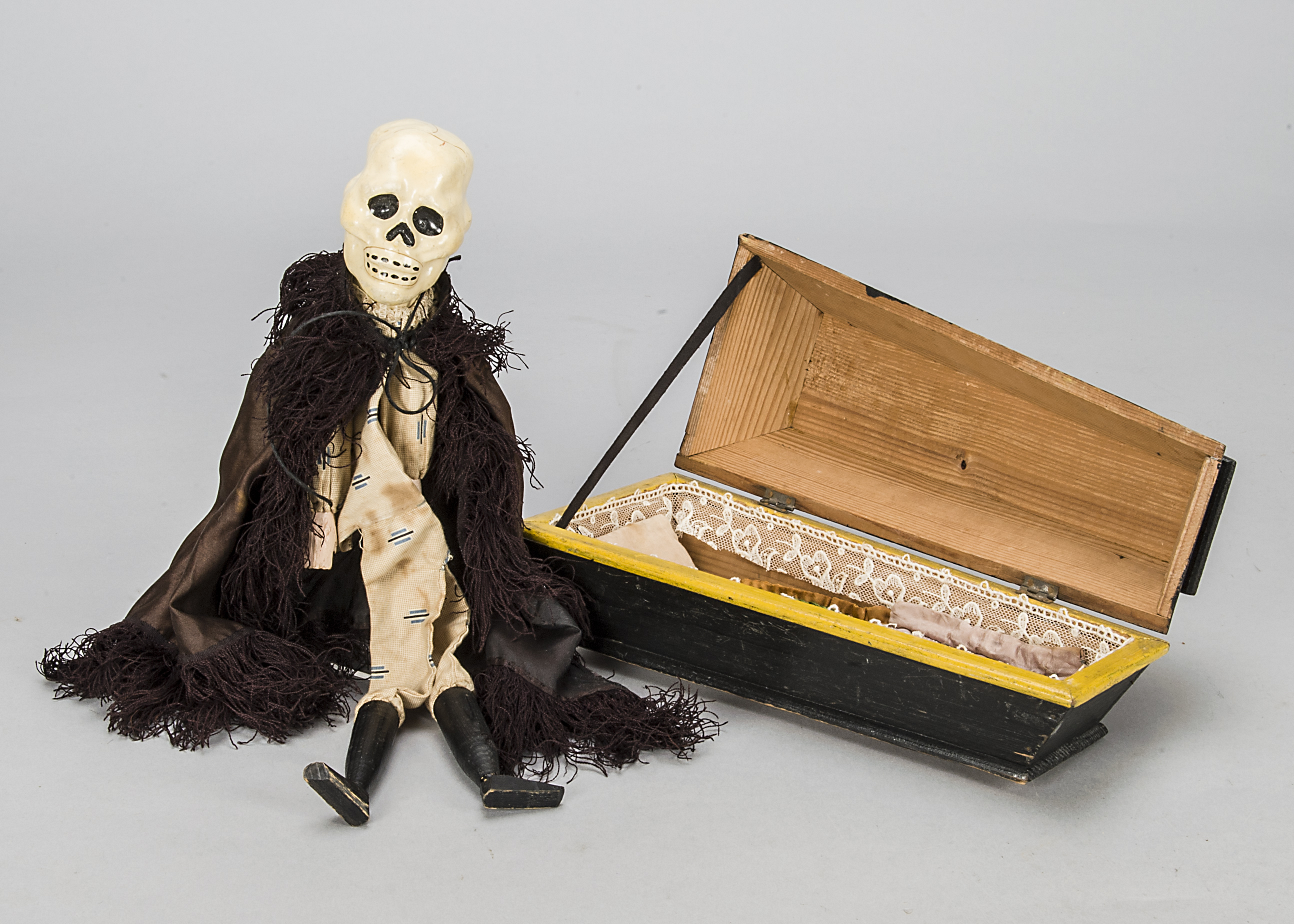 An unusual toy or model coffin, probably late 19th century with embossed paper decoration, painted