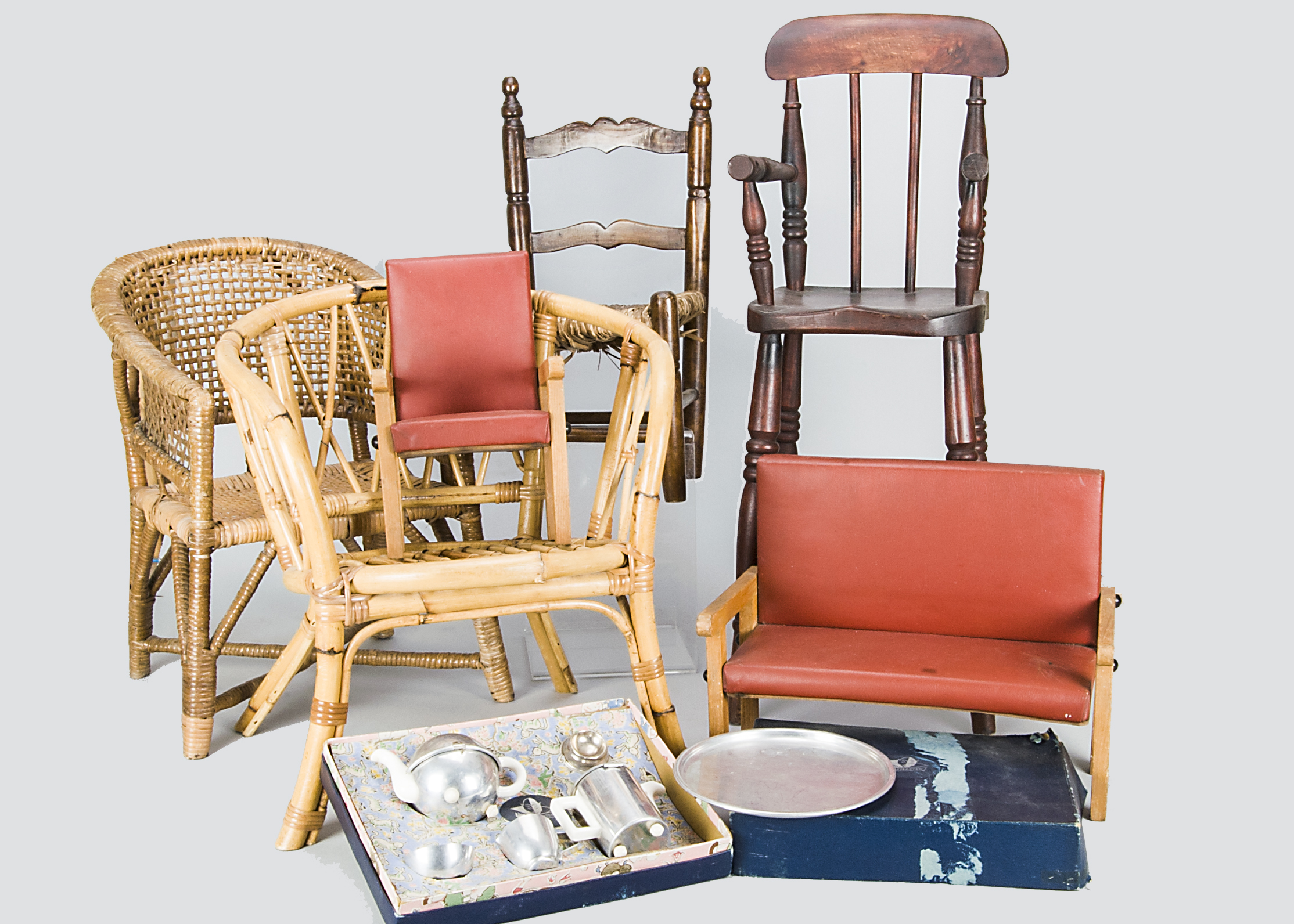 Various children and doll’s chairs, including a high chair, a bamboo and wicker chair, an oak county