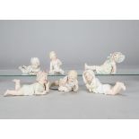 Six German bisque babies, one lying holding a toy lamb —7in. (18cm.) long, another leaning back with