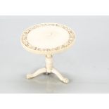 A fine 19th century ivory dolls’ house tripod occasional table, with finely carved floral edge to