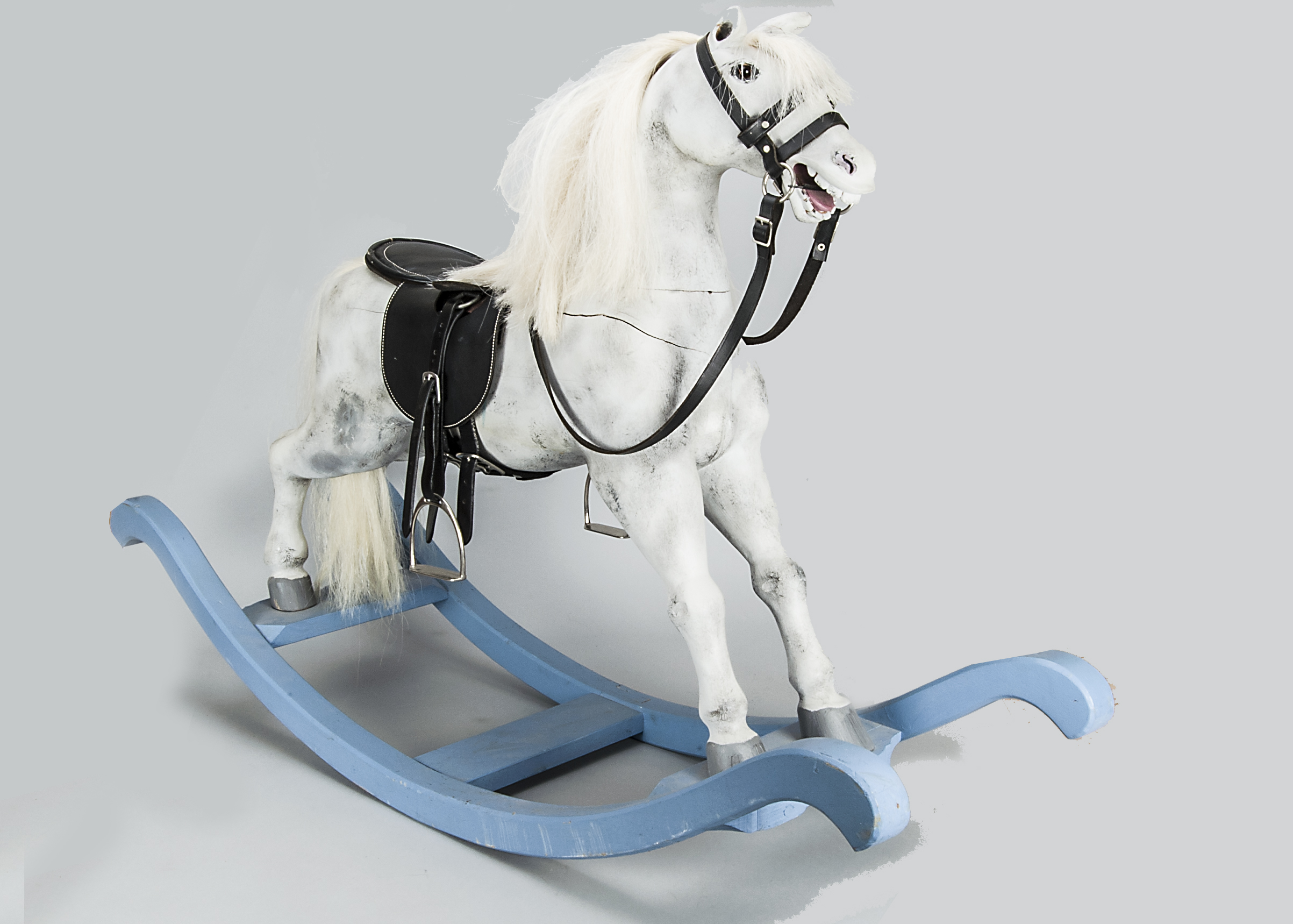 A carved wooden rocking horse, of recent manufacture with leather saddle and bow rocker —56in. (