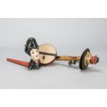 A one-man band instrument with devil’s head, the composition devil’s head surmounts a wooden pole