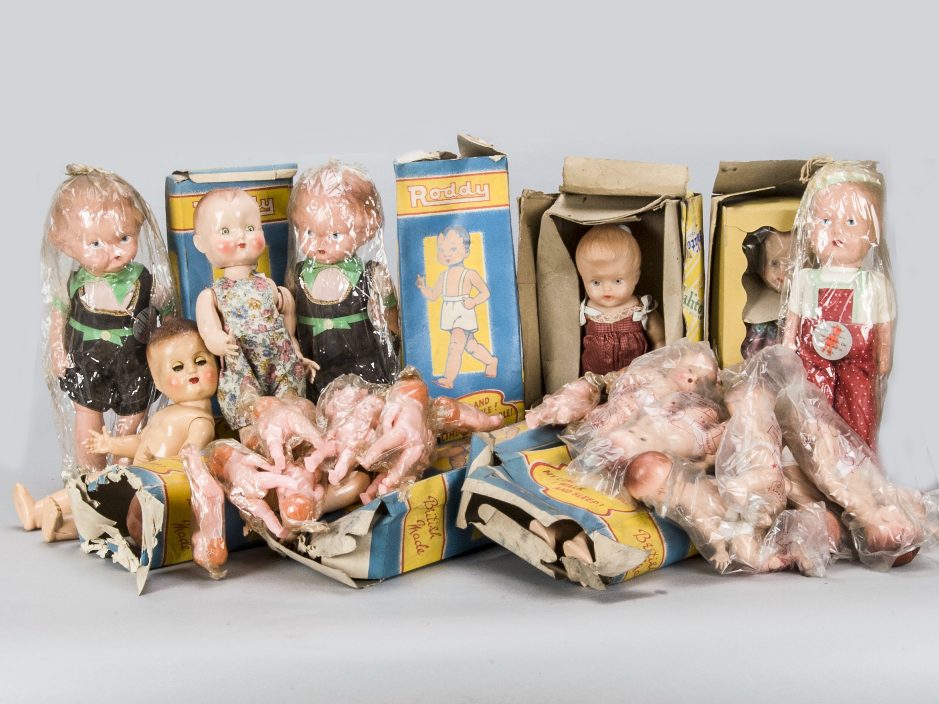 A large quantity of British hard plastic dolls, eight Roddy walking dolls, seven in original blue