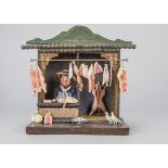 A toy butcher’s shop of recent manufacture, with carved wooden butcher and hanging metal, J Hunt