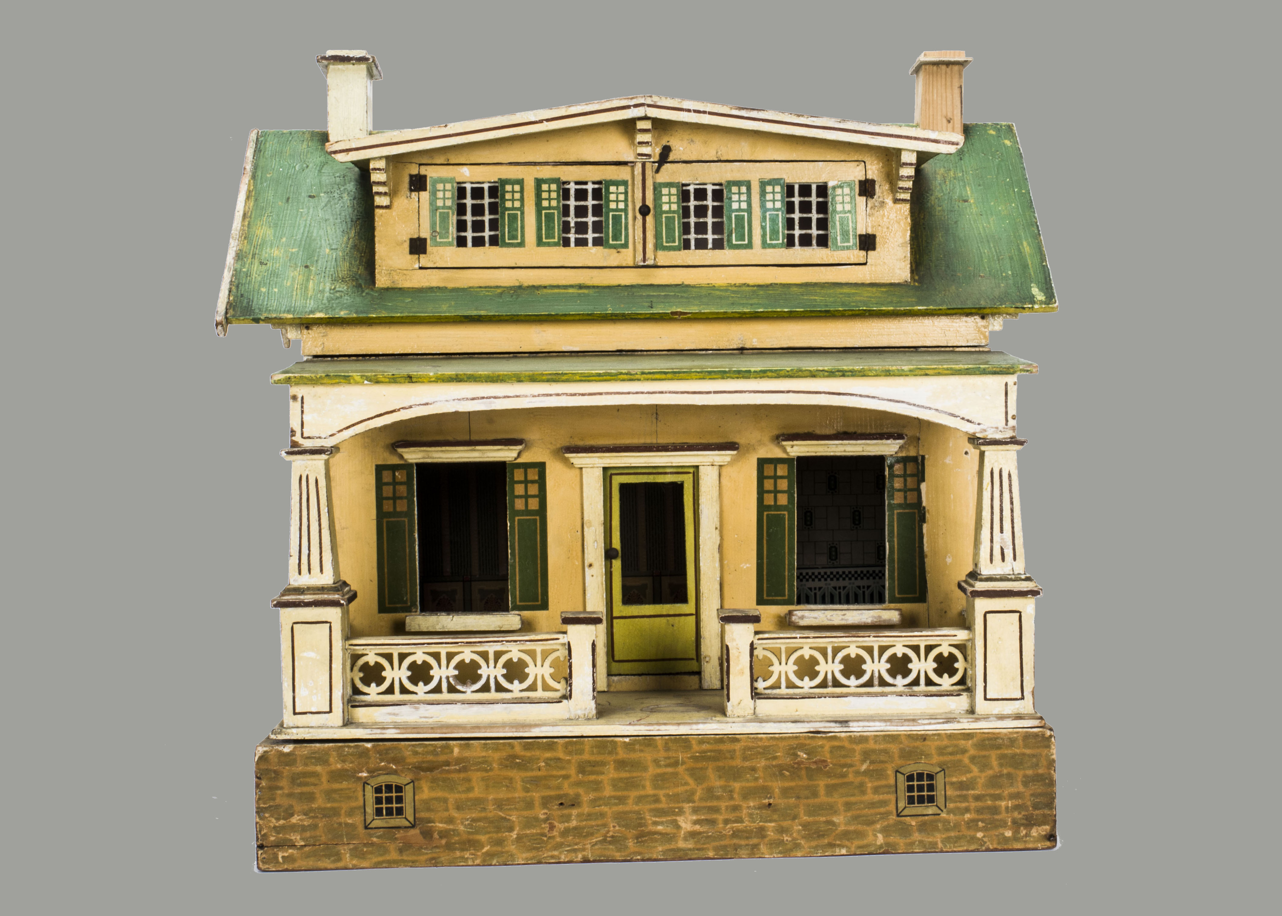 An unusual German dolls’ house for Moko, with cream painted facade, verandah across entire front,