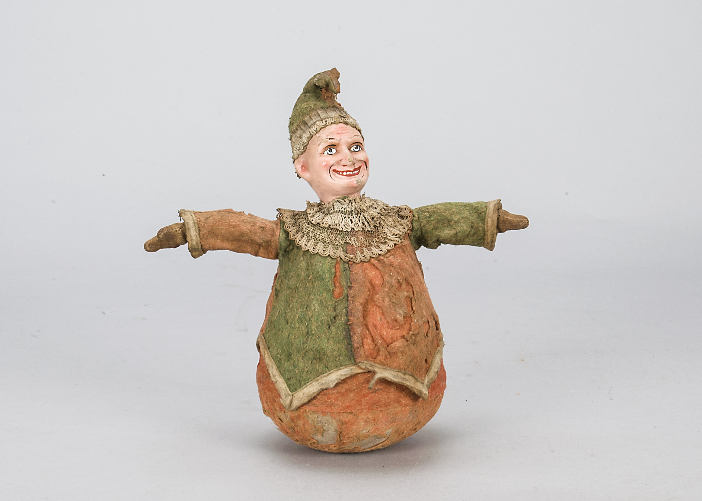 A Mr Punch roly poly toy, with composition painted head, red and green felt costume with matching