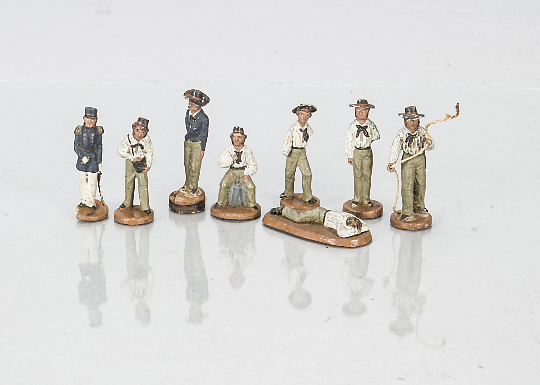 Eight late 19th century German Sonneberg composition sailors, on turned wooden bases, the captain