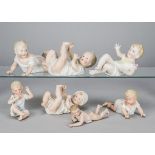 Seven German bisque babies, including Heubach crawling and playing with toes, largest —7in. (