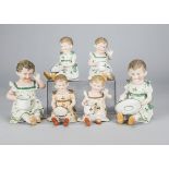 Three pairs of German bisque children with cups and saucers, all seated, one holding a saucer and