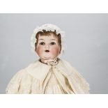 A large Armand Marseille 990 character baby, with lashed brown sleeping eyes, red mohair wig, bent-